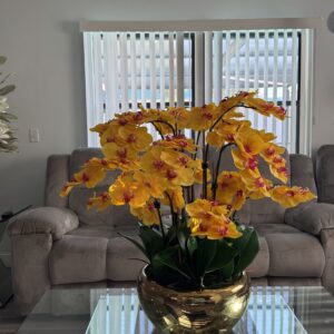 Cascading yellow orchids, gold-colored stainless steel base