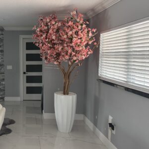 Pink cherry blossom tree on a white beveled vase