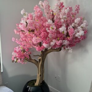 Pink cherry blossom tree on a black round vase