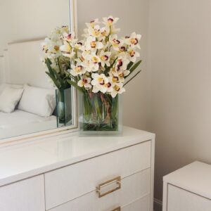 Square glass vase with orchids and natural wood